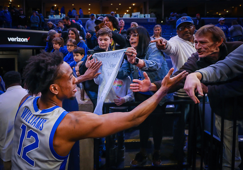 <strong>Tigers forward Deandre Williams (12) signs autographs after the win against Temple on Sunday.</strong> (Patrick Lantrip/The Daily Memphian)
