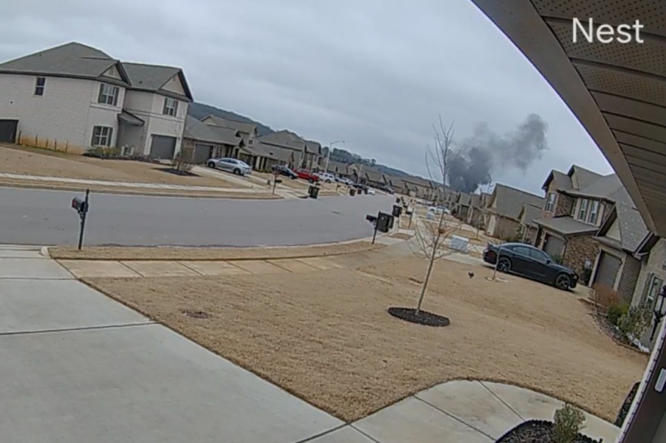 <strong>In this image made from video taken from a Nest camera provided by Mia McShan, a cloud of black smoke rises from where a Black Hawk helicopter crashed on Wednesday, Feb. 15, 2023, in Alabama.</strong> (Mia McShan via AP)