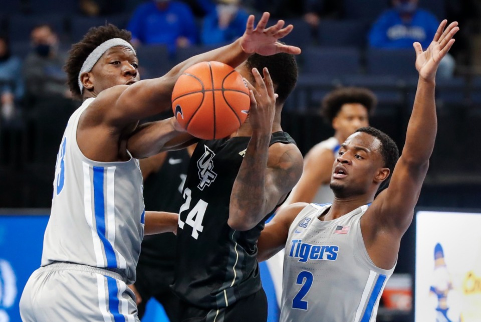 <strong>Tigers defenders Malcolm Dandridge (left) and Alex Lomax (right) apply defensive pressure to UCF forward Dre Fuller Jr. (middle) during action on Wednesday, Feb. 3, 2021.</strong> (Mark Weber/The Daily Memphian)