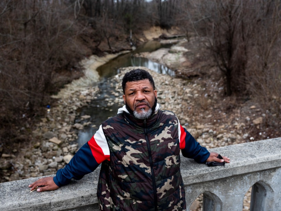 <strong>Reginald Monroe stands on the Watkins Street bridge over Cypress Creek where he fell 60 feet in 2016 while fleeing from police following an illegal search of his car.&nbsp;</strong>(Brad Vest/Institute for Public Service Reporting)