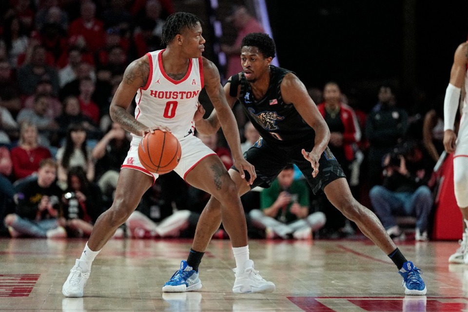 <strong>Houston guard Marcus Sasser is defended by Memphis guard Elijah McCadden during the first half of an NCAA college basketball game Sunday, Feb. 19, 2023, in Houston.</strong> (AP Photo/Kevin M. Cox)