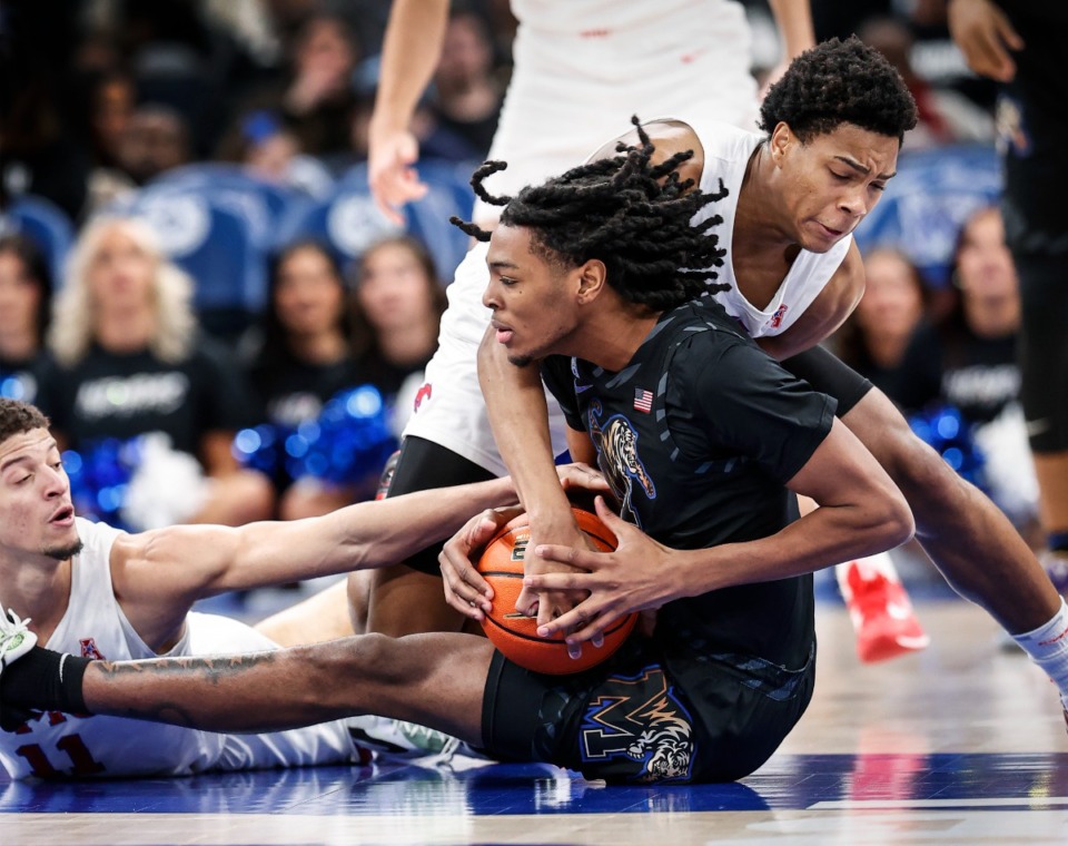 <strong>Tigers forward Johnathan Lawson (middle, in a Jan. 26 file photo) battles SMU defenders Samuell Williamson (left) and Zhuric Phelps (right) for a loose ball during action at FedExForum.</strong> (Mark Weber/The Daily Memphian)