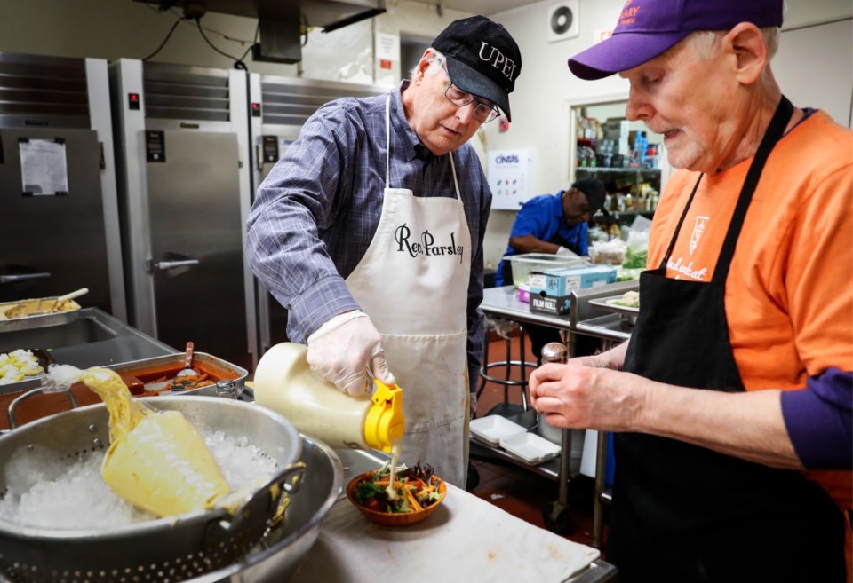 <strong>Calvary Waffle Shop volunteers Ray Hatton (left) and Bob Carlie (right) prepare customer lunches on Thursday, March 3, 2022, at Calvary Episcopal Church.</strong> (Mark Weber/The Daily Memphian file)