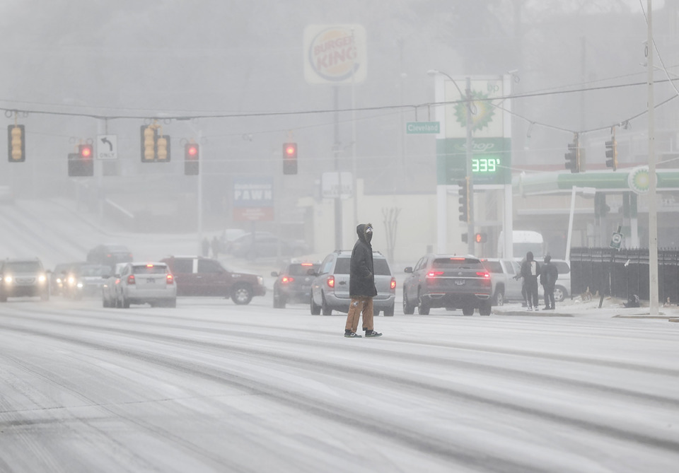 <strong>A pedestrian crosses Poplar Avenue as freezing rain falls.</strong>&nbsp;(Mark Weber/The Daily Memphian file)