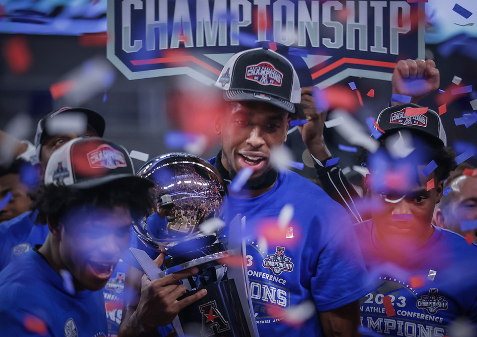 <strong>University of Memphis forward DeAndre Williams holds the AAC Championship trophy after defeating Houston 75-65 on March 12, 2023.</strong> (Patrick Lantrip/The Daily Memphian)