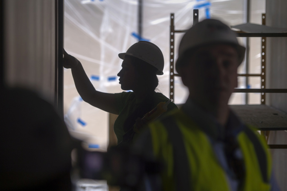 <strong>A worker caulks around a door as Germantown Municipal School District Superintendent Jason Manuel (right) leads a tour through the construction site of Forest Hill Elementary School May 8, 2019, in Germantown.</strong> (Brandon Dill/Special To The Daily Memphian)