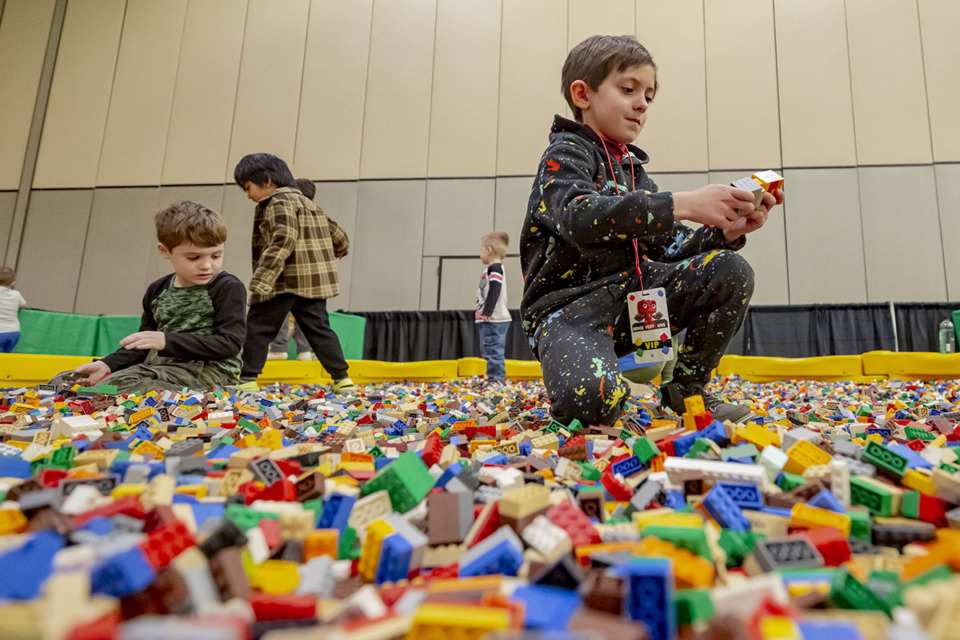 <strong>Cameron Schmidt (center) plays in large Lego brick pool pit during&nbsp;Brick Fest Live&nbsp;in downtown Memphis on Saturday, March 11, 2023. Festival officials say their goal is to inspire attendees to build their own creations.</strong>&nbsp;(Ziggy Mack/Special to The Daily Memphian)