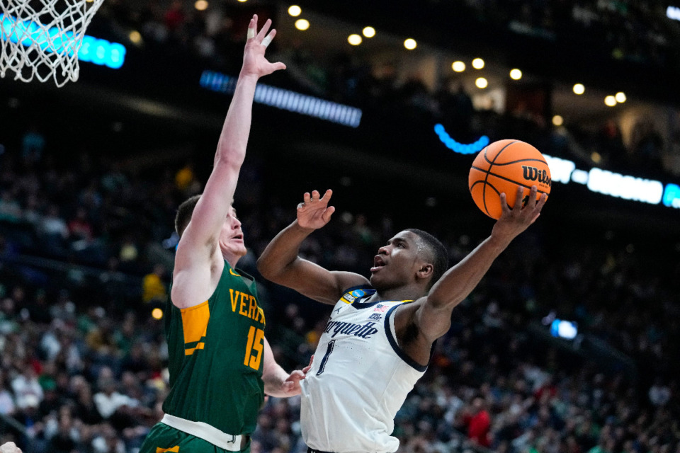 <strong>Marquette guard Kam Jones (1), who starred at Evangelical Christian School, shoots over Vermont guard Finn Sullivan (15) in the second half of a first-round college basketball game in the men's NCAA Tournament in Columbus, Ohio, Friday, March 17, 2023.</strong> (AP Photo/Michael Conroy)