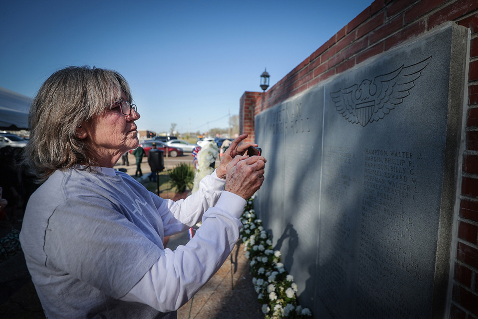 <strong>Jerri Pennington takes a picture of her cousin's name on the Shelby County Vietnam War Memorial during its rededication March 29, 2023.</strong> (Patrick Lantrip/The Daily Memphian)