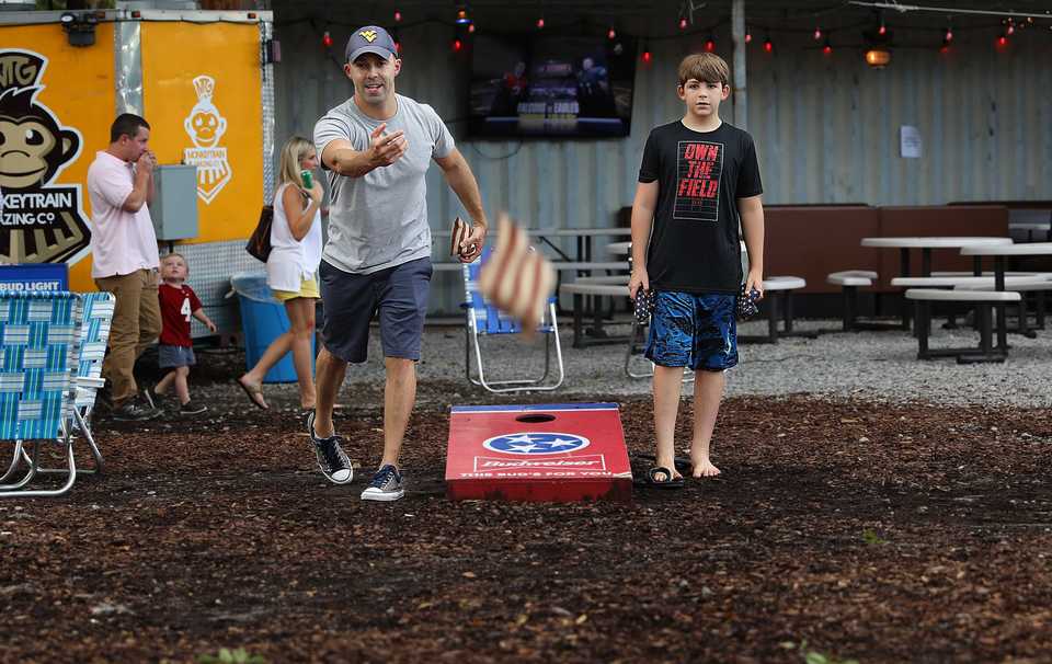 Antonio Perez and Joey Artiles enjoy a friendly game of cornhole at Railgarten on Friday, Aug. 31. The popular venue offers family-friendly activities that range from beach volleyball to ping-pong. (Patrick Lantrip/Daily Memphian)