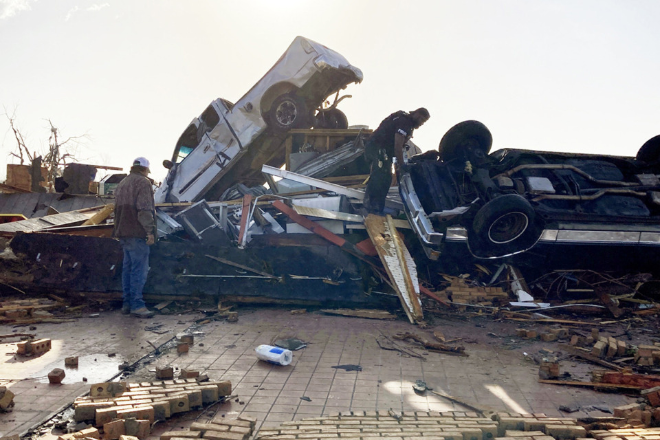 <strong>Law-enforcement officers climb through debris on a diner looking for survivors early March 25 in Rolling Fork, Miss. No one was found.</strong> (Rogelio Solis/AP Photo)