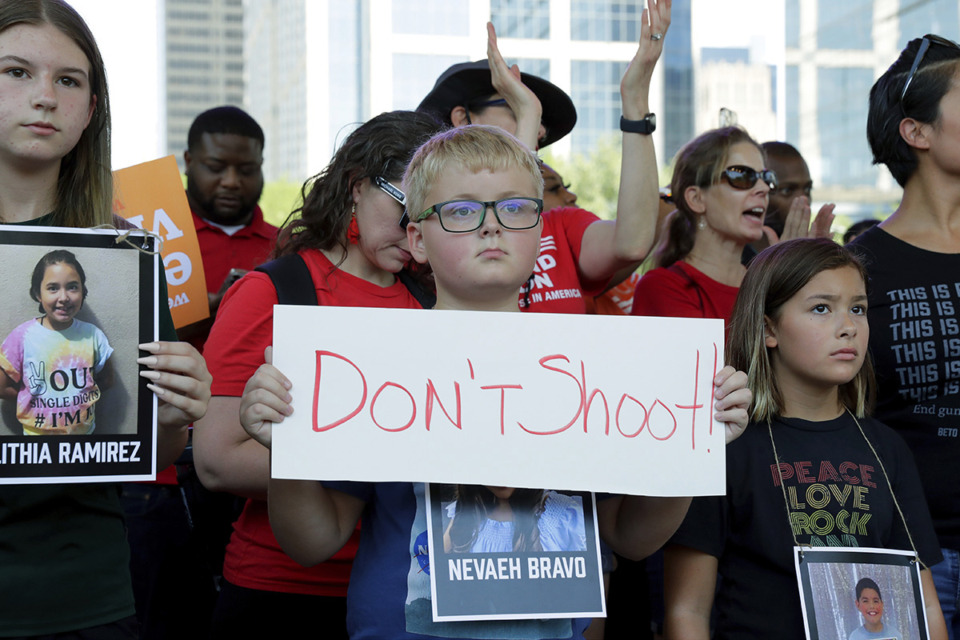 <strong>Children hold signs and photos of the Uvalde, Texas school shooting victims during a rally May 27, 2022, in Houston.</strong> (Michael Wyke/AP Photo file)