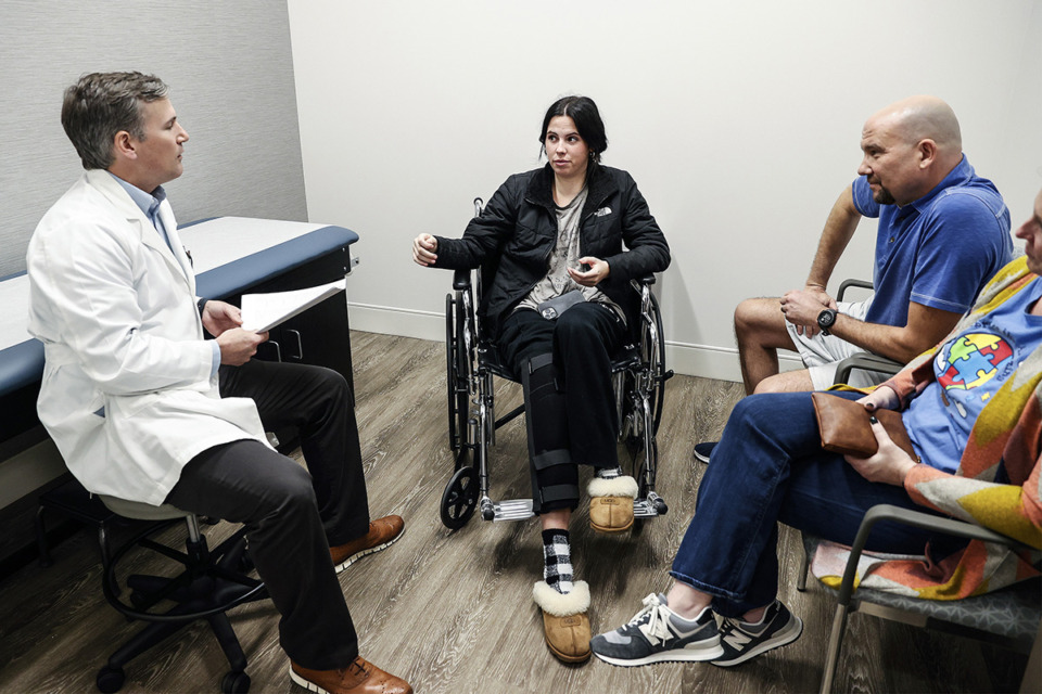 <strong>OrthoSouth orthopedic surgeon Marcus Biggers (left) speaks with patient Izzy Ellis, 17, (middle) and her parents on Monday, April 3, 2023. OrthoSouth&nbsp;treats the school&rsquo;s athletes through an agreement with the Arlington school district.</strong> (Mark Weber/The Daily Memphian)
