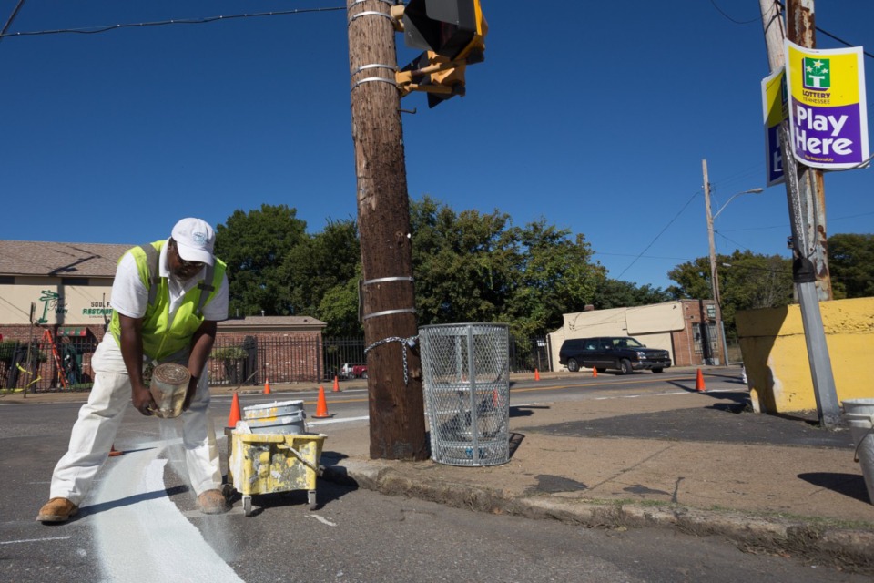 <strong>Percy Seldon puts a fresh lane marker down at the intersection of Mississippi and Walker in Soulsville in preparation for MEMFix in 2013.</strong> (Daily Memphian file)