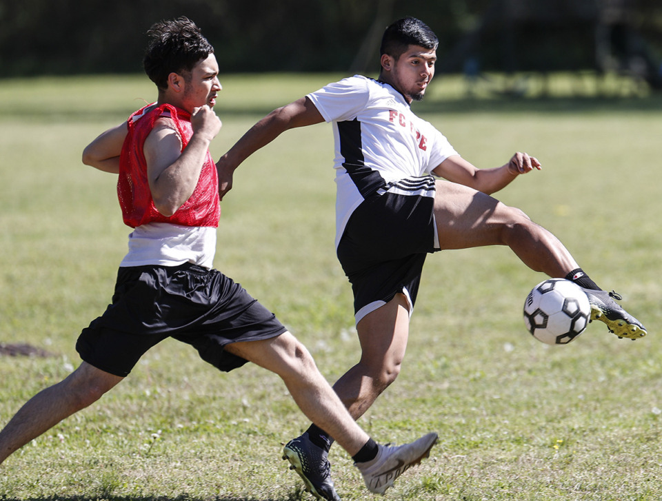 <strong>Memphis Business Academy soccer player Jovanny Martinez (right) attacks the ball during practice on Tuesday, April 11, 2023.</strong> (Mark Weber/The Daily Memphian)