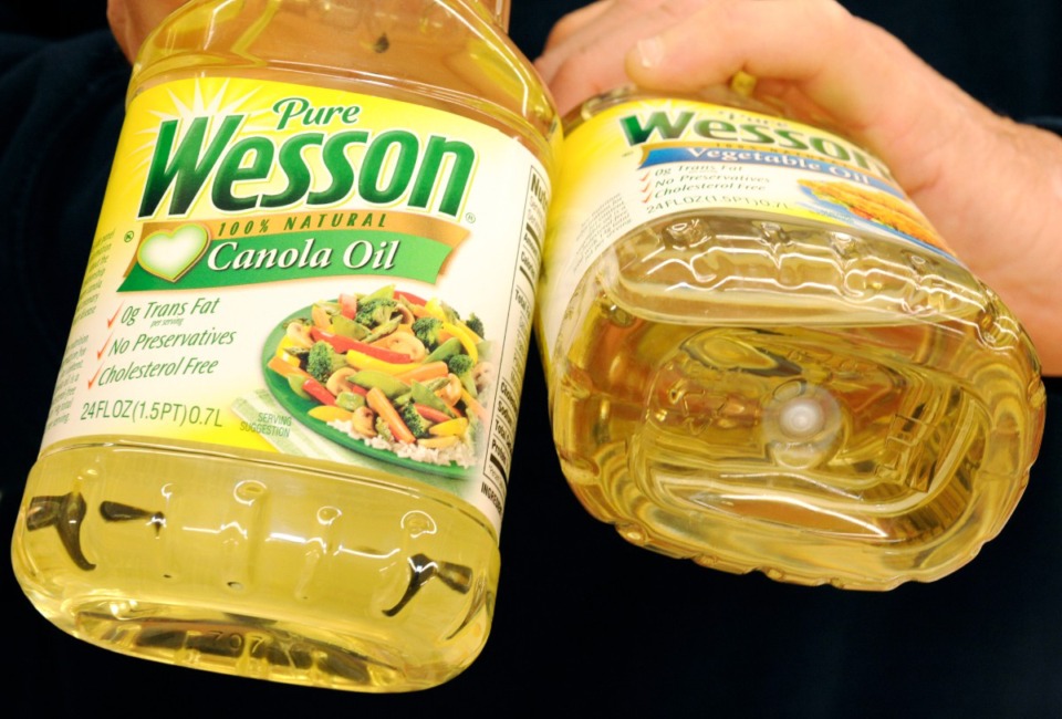 <strong>A customer holds up bottles of Wesson Oil at a grocery store, Friday, May 15, 2009 in Danvers, Mass.&nbsp;Richardson International plans to invest $220 million to upgrade its Wesson Oil plant in Midtown Memphis.</strong> (AP Photo/Lisa Poole)