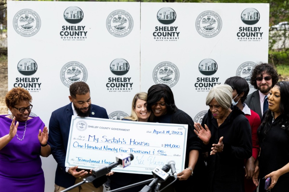 <strong>Kayla Rena Gore (center right), co-founder of My Sistah&rsquo;s House, and Jerri Green (center left), senior policy advisor for Shelby County Mayor Lee Harris, hug during a ceremony where the county invested $194,000 in transitional housing for My Sistah&rsquo;s House.</strong> (Brad Vest/Special to The Daily Memphian)