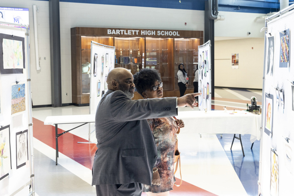 <strong>Kenneth Hayes, left, and his wife, Maureen Hayes, right, look at student artwork during the Bartlett Education Foundation&rsquo;s event that spotlights work from Bartlett High School students Friday, April 14, 2023.</strong> (Brad Vest/Special to The Daily Memphian)