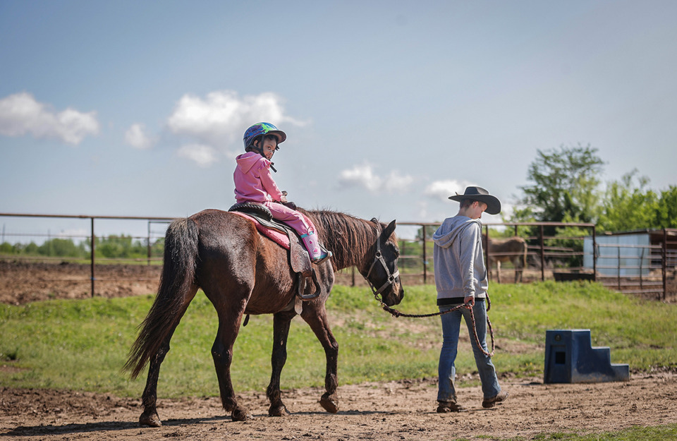 <strong>Ava Anderson, 6, looks back at her family as she goes off on a guided horse ride at Shelby Farms Stables April 22.</strong> (Patrick Lantrip/The Daily Memphian)