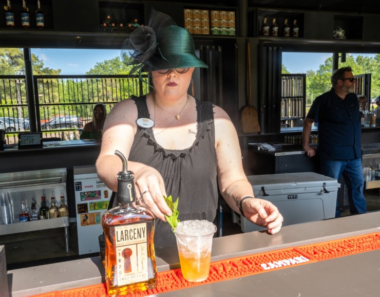 <strong>Edna Dinwiddie serves up a mint julep, a traditional Kentucky Derby drink, at the Derby watch party at the GPAC Outdoor at The Grove, Saturday, May 6, 2023.</strong> (Greg Campbell/Special to The Daily Memphian)