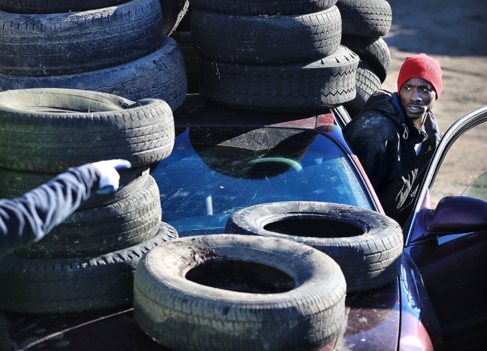 <strong>With 60 tires tied to the top, trunk and hood of his sedan, a customer gets directions to where he can have his tires unloaded in 2019 during the third tire redemption program by Memphis and Shelby County in the last seven years.</strong>&nbsp; (The Daily Memphian files)