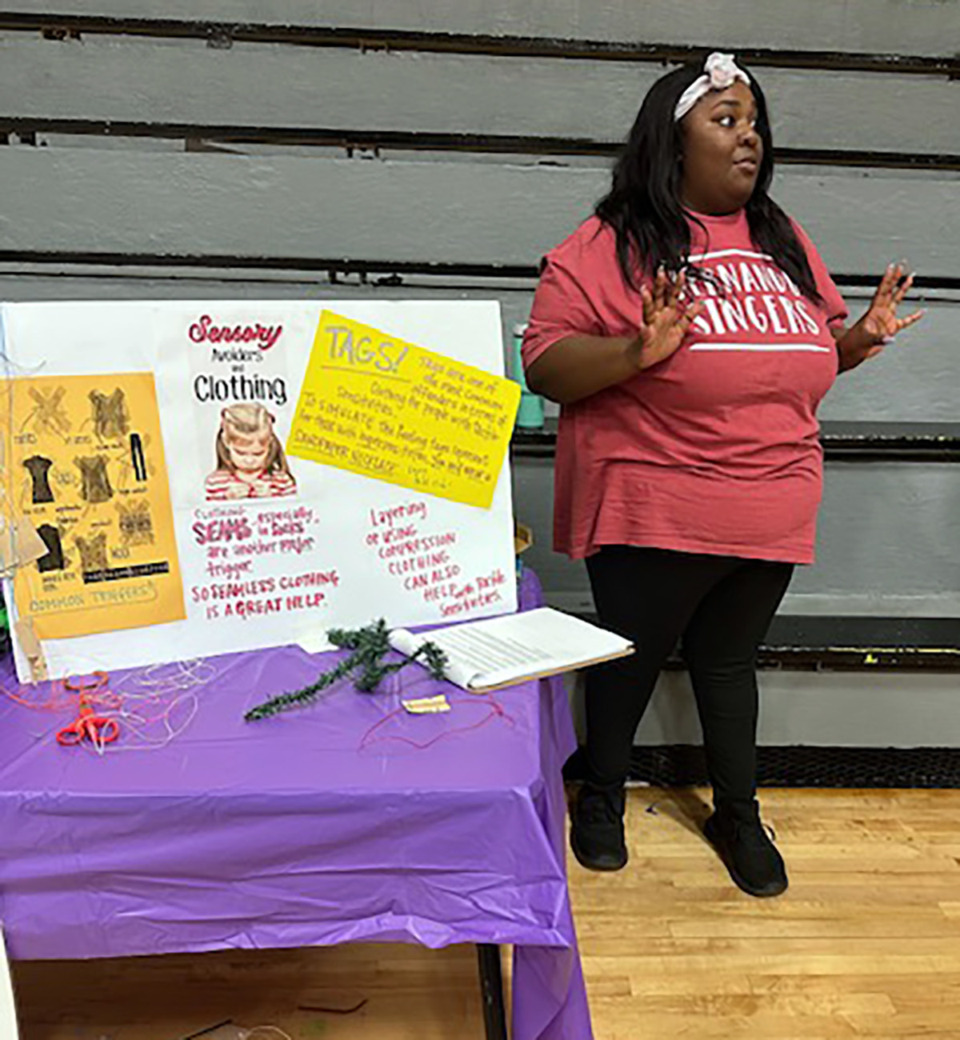 <strong>Jamiria Massie explains possible clothing challenges for people with tactile defensiveness at the Hernando High School sensory awareness exhibit. Those with the challenge may be overwhelmed by clothing textures, tightness, tags and seams.</strong> (Courtesy Collierville Balloon Festival and DeSoto County Schools)