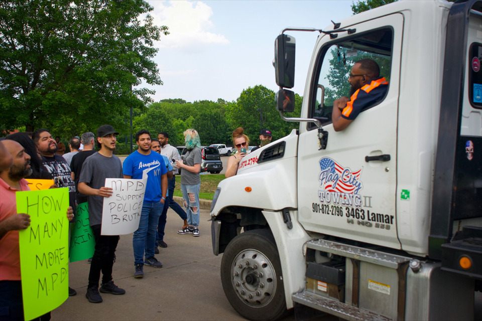 <strong>Protestors exchange words with a tow truck driver as he attempts to enter the Ridgeway precinct lot. The driver</strong> <strong>eventually left and did not return.</strong> (Aarron Fleming/The Daily Memphian)