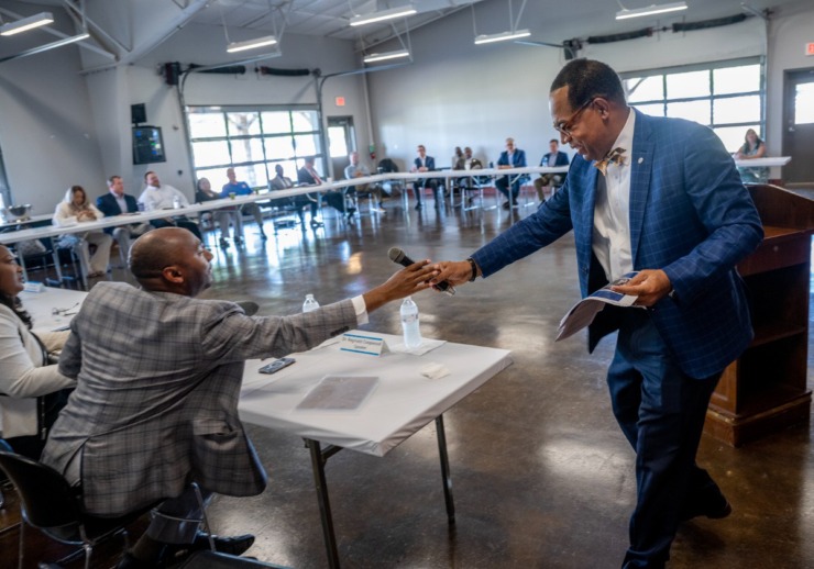 <strong>Dr. Reginald Coopwood passes the microphone to Shelby County Mayor Lee Harris after his presentation to the Shelby County Joint Economic and Community Development Board Thursday, June 1, 2023.</strong> (Greg Campbell/Special to The Daily Memphian)