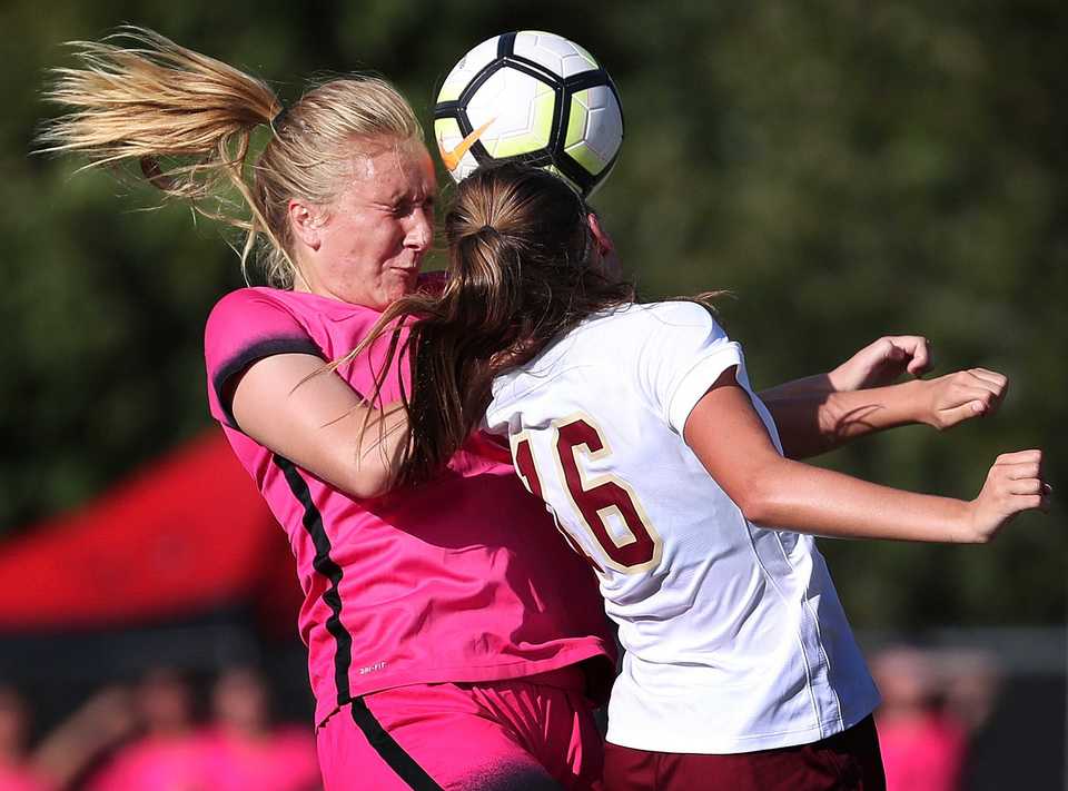 Houston's Peyton Gelinas collides with Annie Todd from ECS during Houston High School's soccer game against ECS at Houston Middle School on August 28, 2018. (Jim Weber/Daily Memphian)