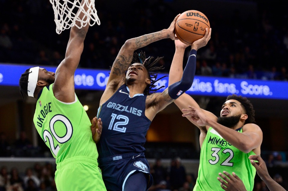 <strong>Memphis Grizzlies point guard Ja Morant throws the ball between Josh Okogie and Karl-Anthony Towns of the Minnesota Timberwolves in overtime in the game Monday, Nov. 8, 2021.</strong> (AP Photo / Brandon Dill)