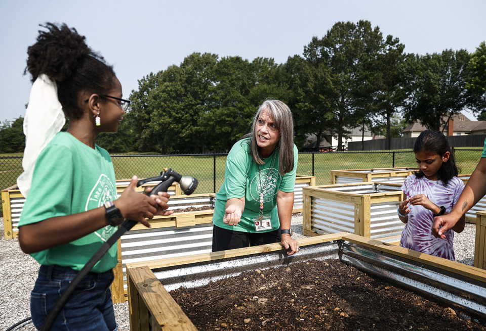 <strong>Tara Oaks Elementary School fifth-grade science teacher Risa Elder (middle) works with students in the school&rsquo;s new flowerbeds.&nbsp;Elder had the idea to start a school garden to teach students about the process of growing food.</strong>&nbsp;(Mark Weber/The Daily Memphian)