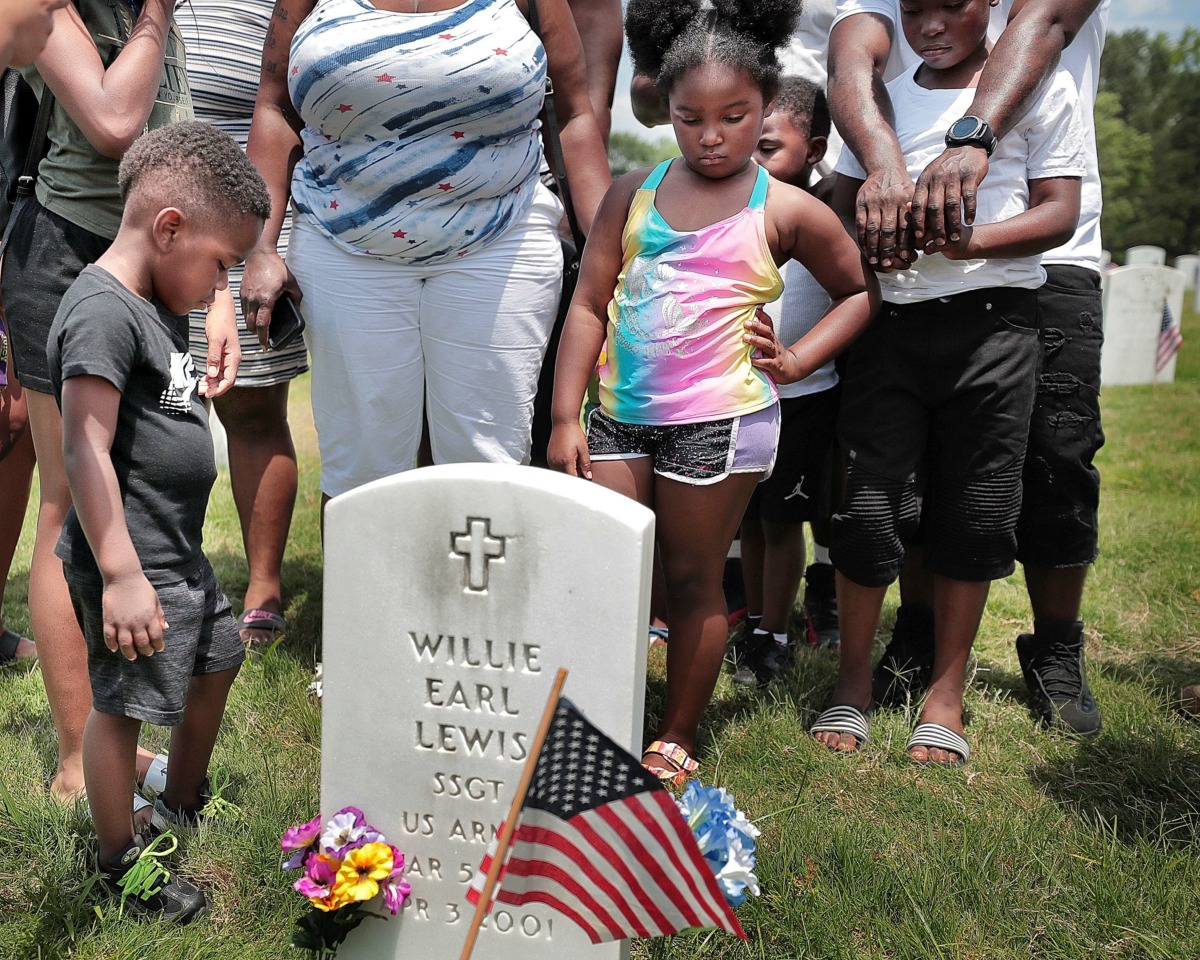 <strong>Family members gather around the grave of U.S. Army Sgt. Willie Earl Lewis to pay their respects after the annual Memorial Day ceremony at the West Tennessee State Veterans Cemetery on Monday, May 27.</strong> (Jim Weber/Daily Memphian)