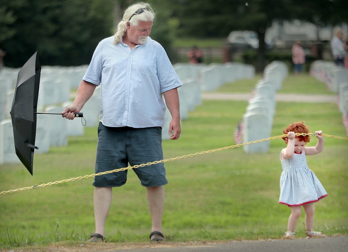 <strong>Keegan Wagner, 3, tries to find her own way out of the cemetery as she walks with her grandfather Lonny Daugherty after the annual Memorial Day ceremony at the West Tennessee State Veterans Cemetery on Monday, May 27.</strong> (Jim Weber/Daily Memphian)