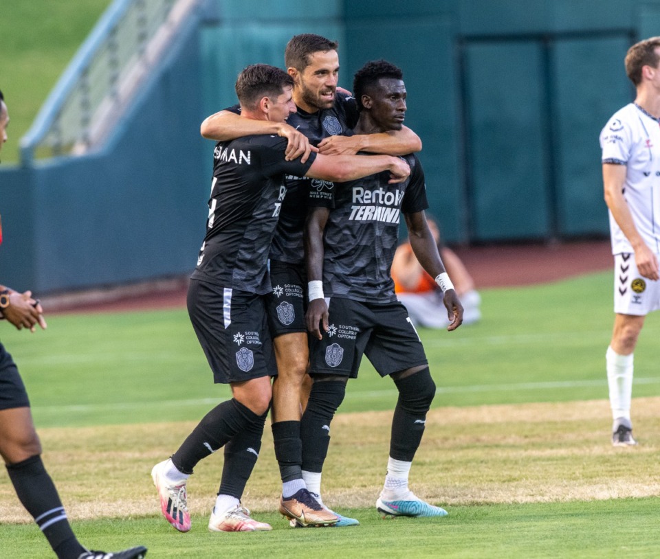 <strong>901 FC's Henderson Hyndman (left) and Rodrigo da Costa (center) grab teamate Laurent Kissiedou after he scores in the first period of Saturday's match against Charleston at AutoZone Park. Memphis would go on to score two more goals to defeat Charleston 3-2.</strong> (Greg Campbell/Special for The Daily Memphian)