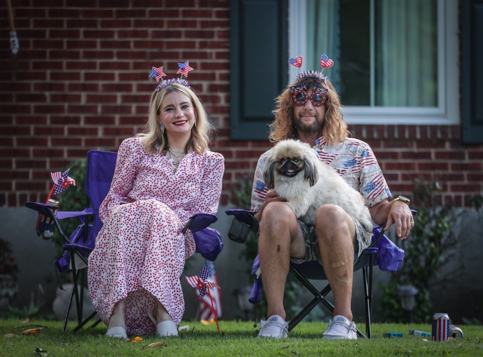 <strong>Megan Bonner, Jeff Burris and their pet, Ding Ding Dog, sit on their lawn while watching the High Point Terrace Fourth of July parade July 4, 2023.</strong> (Patrick Lantrip/The Daily Memphian)
