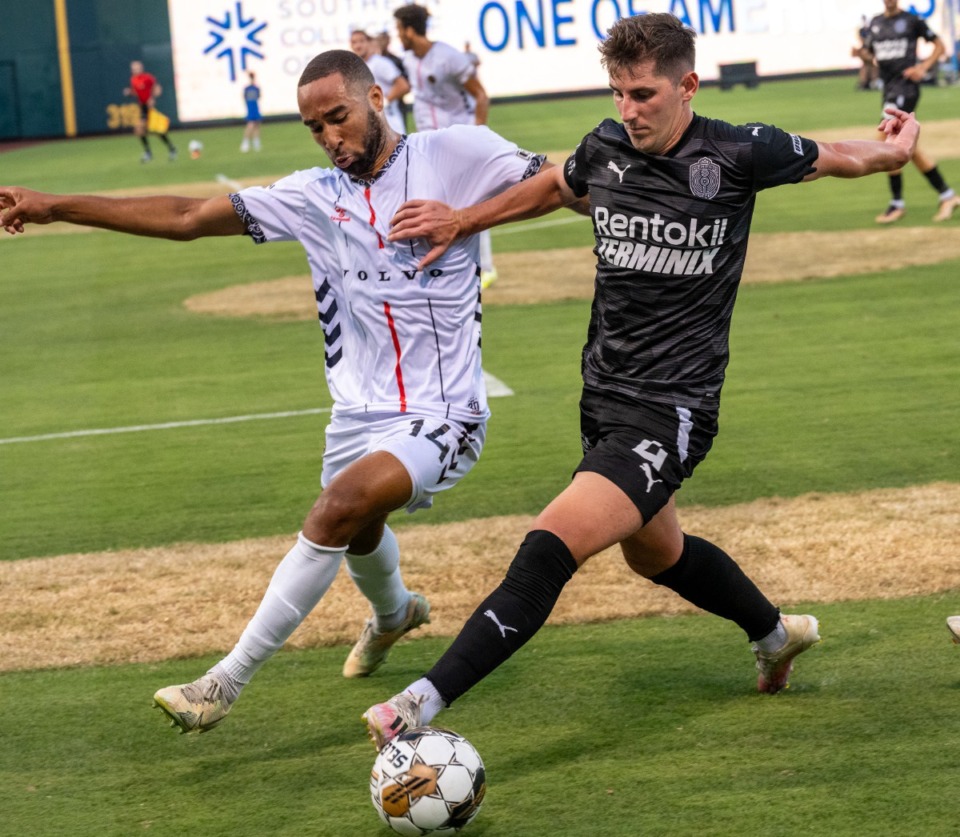 <strong>901 FC midfielder Henderson Hyndman (right) battles for the ball against Charleston Battery's Derek Dodson in Saturday's match at AutoZone Park. 901 FC defeated Charleston 3-2. The team will play San Antonio Friday, July 7, at AutoZone Park.</strong> (Greg Campbell/Special for The Daily Memphian file)