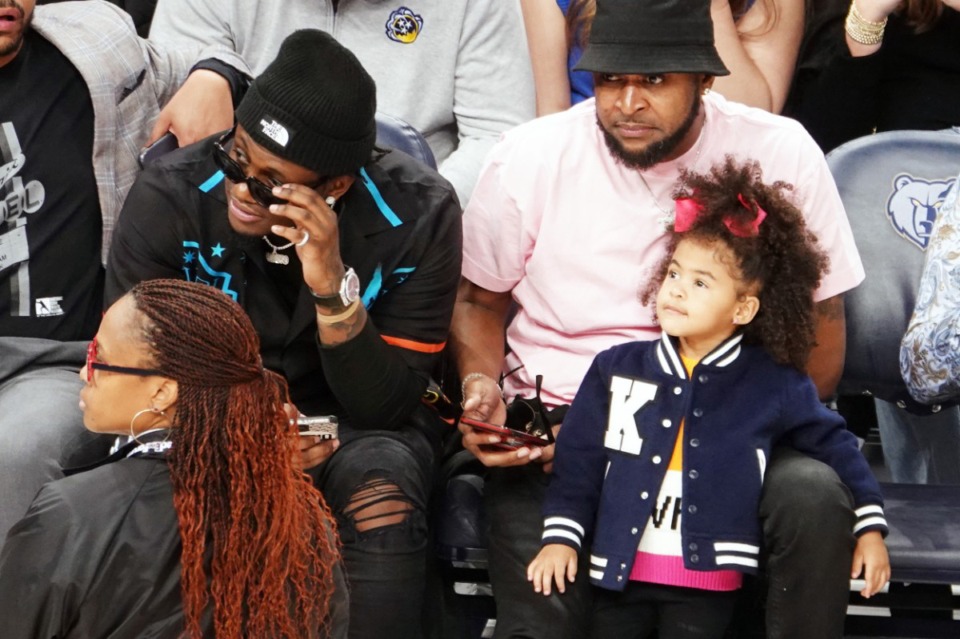 <strong>Davonte Pack (left) sits on the court of a Memphis Grizzlies game at FedExForum with Tee Morant, Ja Morant's father, and Ja's daughter Kaari Morant Jan. 16.</strong> (Karen Pulfer Focht/Special to The Daily Memphian)