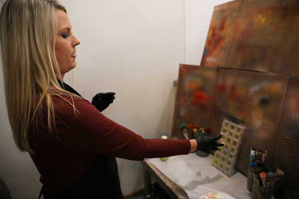 <strong>Rebecca Hartman splashes edible pink and green cocoa butter paint on the mold while designing her signature chocolate at Phillip Ashley Chocolates.</strong> (Patrick Lantrip/Daily Memphian)