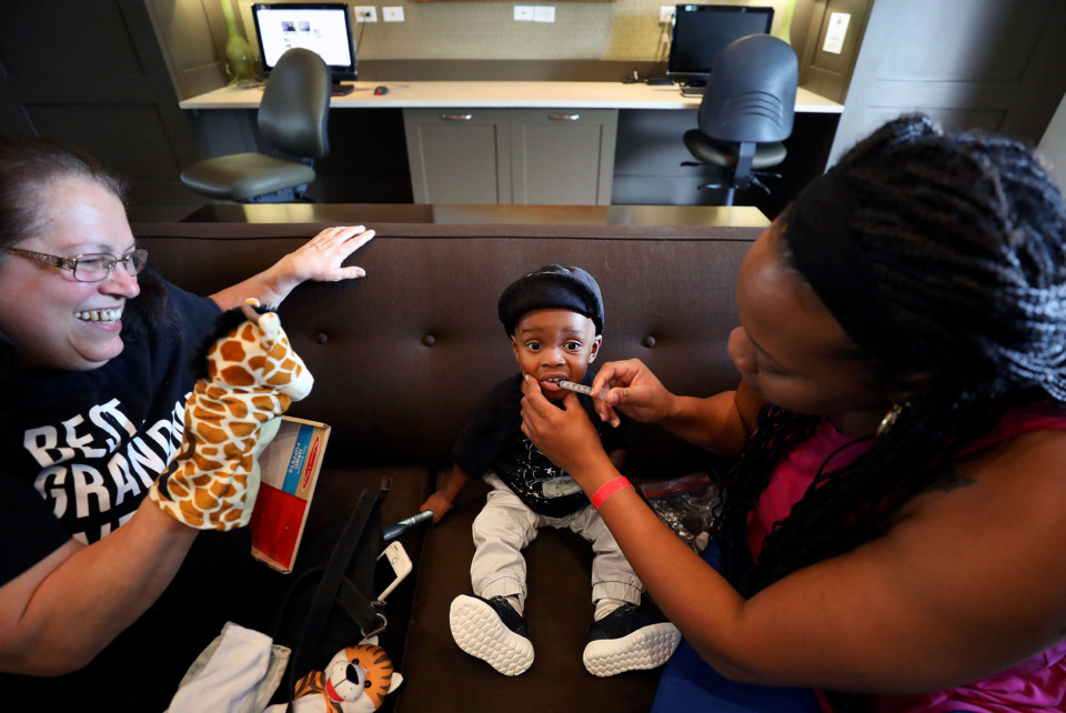 <strong>Nicole Box gives her son, Zanick Masters, a dose of medicine while Gift of Life Mid-South volunteer Joanie Bergstrom tries to entertain the 13-month-old at the FedEx Family House on Friday, May 31. Box, from Jamaica, brought her son to Memphis to get treatment at Le Bonheur Children's Hospital for a congenital heart defect. Zanick's treatment was made possible by Gift of Life Mid-South. </strong>(Patrick Lantrip/Daily Memphian)