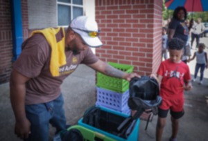 <strong>Eric Lay passes out backpacks at Manassas High School where the The UPS Women and Men of Brown gave away 300 free backpacks filled with school supplies Saturday, July 29.</strong> (Patrick Lantrip/The Daily Memphian)