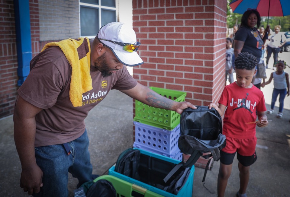 <strong>Eric Lay passes out backpacks at Manassas High School where the The UPS Women and Men of Brown gave away 300 free backpacks filled with school supplies Saturday, July 29.</strong> (Patrick Lantrip/The Daily Memphian)