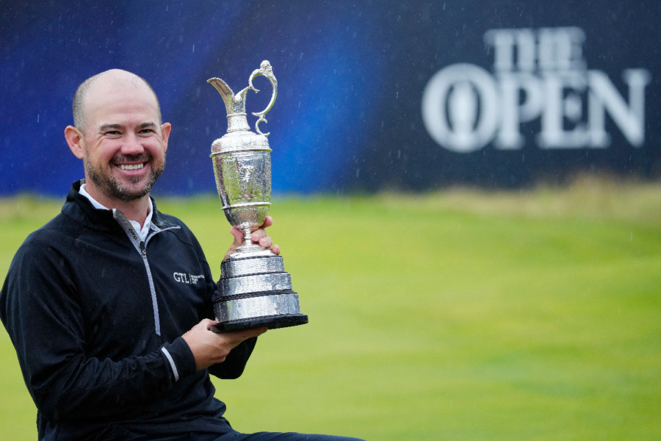 <strong>Brian Harman poses for the media as he holds the Claret Jug trophy for winning the British Open Golf Championships at the Royal Liverpool Golf Club in Hoylake, England July 23.</strong> (Jon Super/AP Photo)