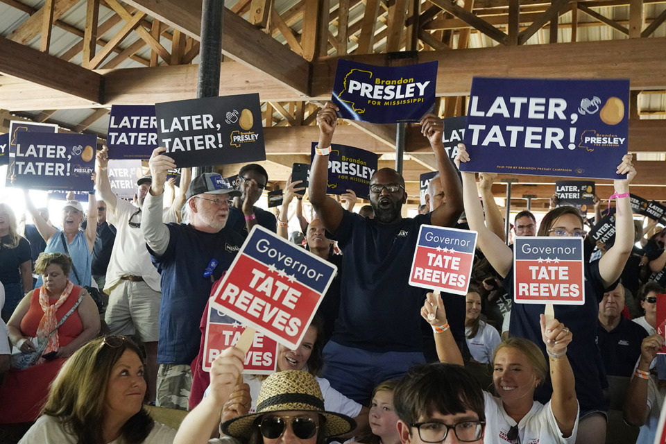 <strong>Contrasting groups of supporters for the incumbent Mississippi Gov. Tate Reeves and Democrat Brandon Presley wave their respective candidates' signs at the Neshoba County Fair in Philadelphia, Miss., Thursday, July 27.</strong> (Rogelio V. Solis/AP file)