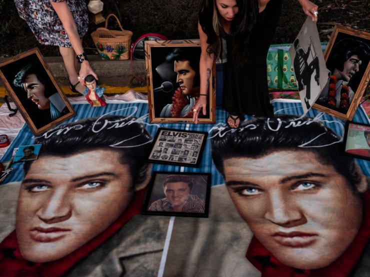 <strong>Meredith Benson, left, and Celine Lee examine memorabilia at the Candlelight Vigil at Graceland Aug. 15.&nbsp;</strong>(Brad Vest/Special to The Daily Memphian)