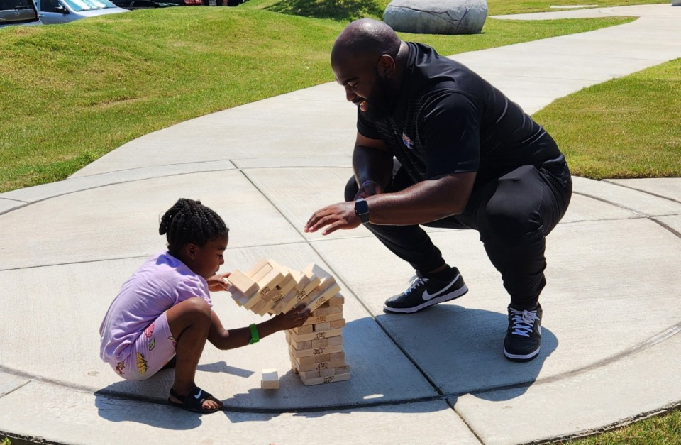 <strong>University of Memphis defensive line coach Kyle Pope plays Jenga with a patient from Le Bonheur Children's Hospital while the Tigers were there for an event Friday, Aug. 18, 2023.</strong> (Frank Bonner/The Daily Memphian)