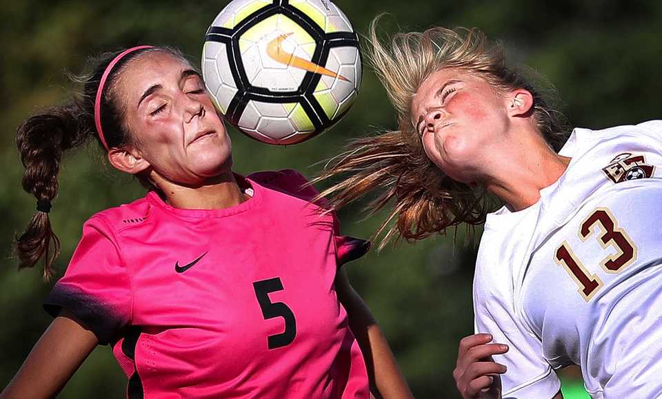 The Mustang's Sydney Somogyi (5) battles for control of a header against Phoebe Harpole (13) from ECS during Houston High School's soccer game against ECS at Houston Middle School on August 28, 2018. (Jim Weber/Daily Memphian)