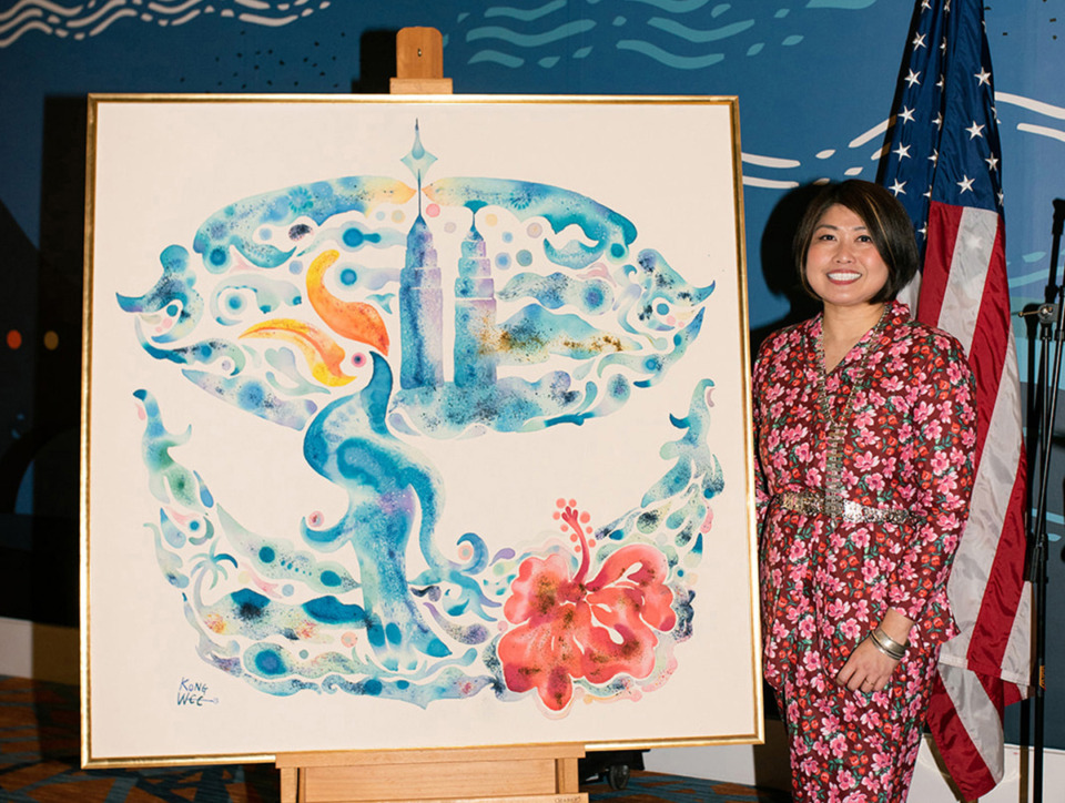 <strong>Kong Wee Pang, a Memphis artist, poses with the 2023 Memphis in May International Festival annual poster which honors Malaysia. The Memphis Chamber will announce the 2024 honored country next week as they take over the international connections for the festival.</strong> (Courtesy Ally Perkins)