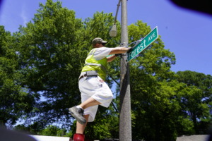 <strong>City of Memphis painter apprentice Alan Fogler attaches the new "Forest Ave" sign at Forest and Freeman.</strong> (Tom Bailey/The Daily Memphian)&nbsp;