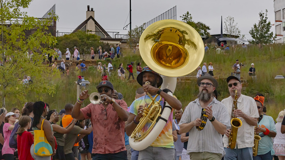 <strong>Victor Sawyer (center) of Mighty Souls Brass Band leads the crowd toward Tom Lee Park for its reopening in Downtown Memphis Saturday, Sept. 2, 2023.</strong> (Ziggy Mack/Special to The Daily Memphian)