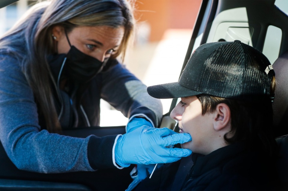 <strong>Collierville High School&rsquo;s Certified Medical Assistant Jaimee Lapham (left) administers a COVID-19 test to middle school student Brayden Mackiewicz on Tuesday, Jan. 11, 2022 at drive-thru testing site at the high school.</strong> (Mark Weber/The Daily Memphian file)